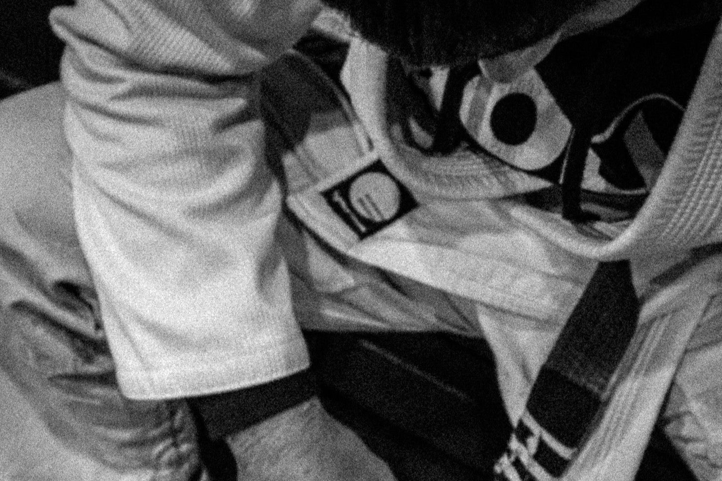 Person wearing a rubber brand jiu jitsu gi, sitting on a chair.